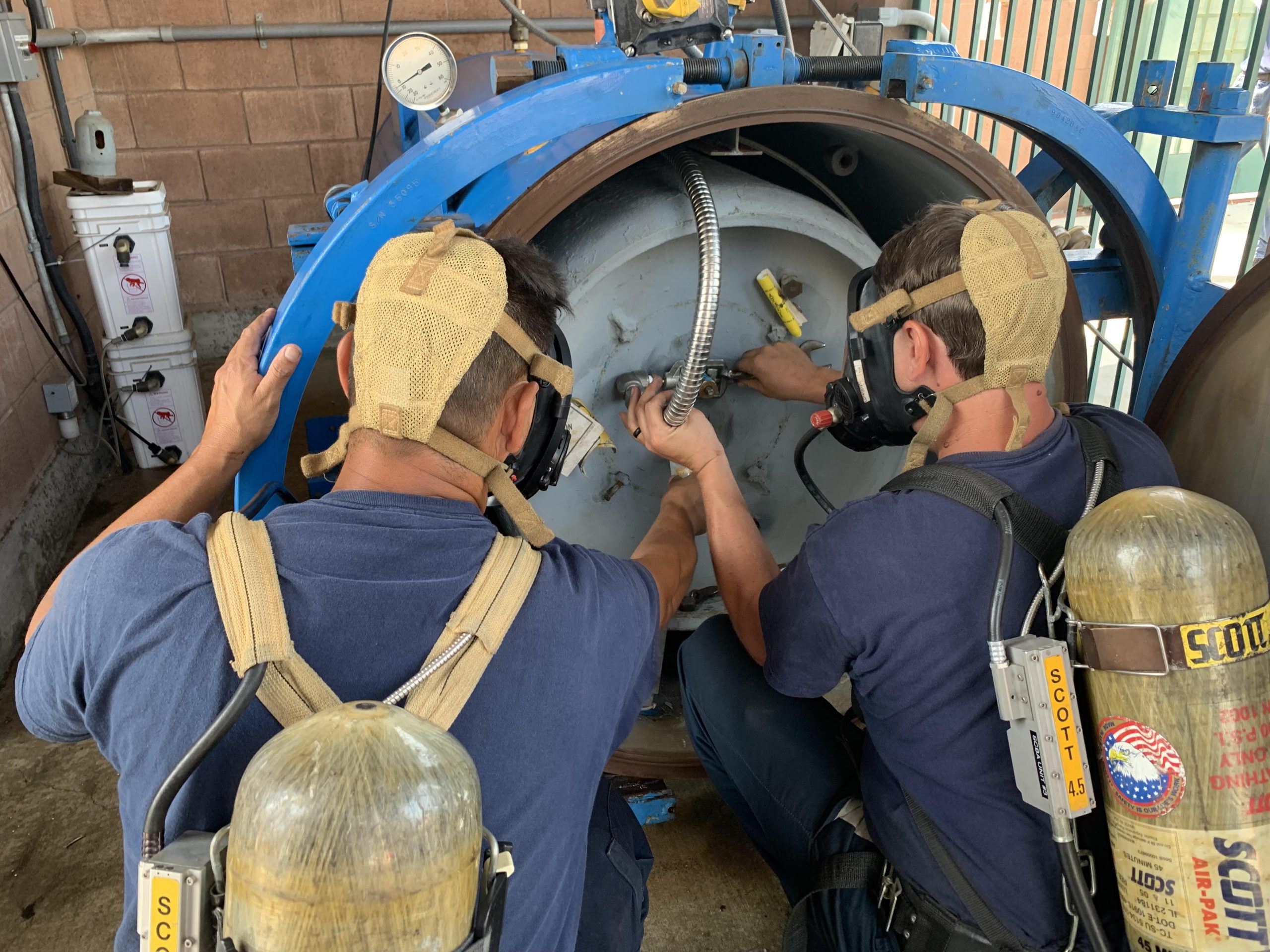 ChlorTainer chemical container. Image of a chlorine technician switching out a ton cylinder of chlorine